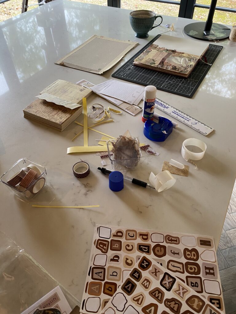 messy surface full of junk journal supplies being used