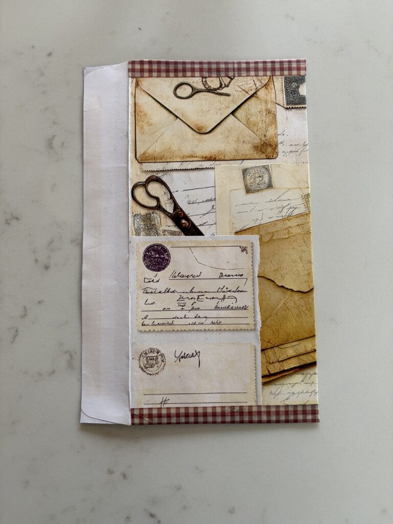 Washi tape added to the sides of an old envelope covered with junk journal ephemera