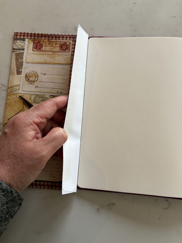 Gluing an ephemera covered envelope into a junk journal