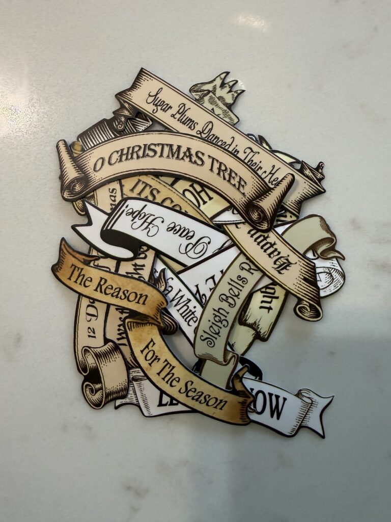 Pile of Christmas stickers with phrases for a junk journal christmas spread.